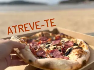 Uma pizza na caixa segurada em frente à baía de São Martinho do Porto